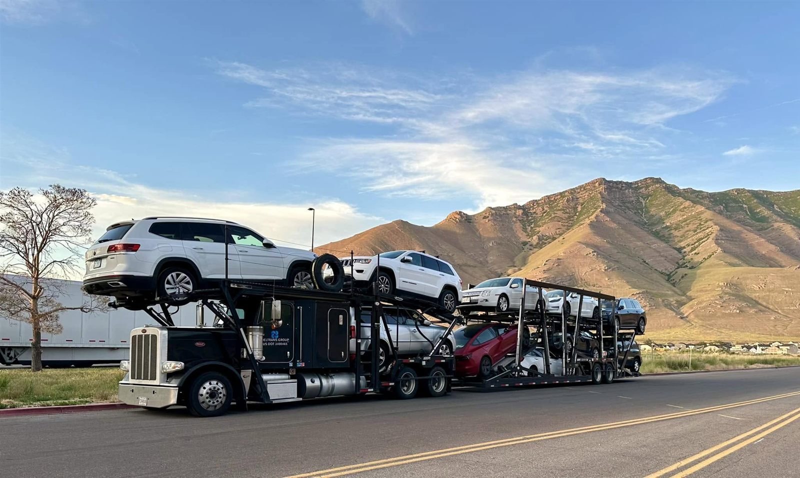 A Deltrans Group car carrier truck hauling vehicles through the mountains